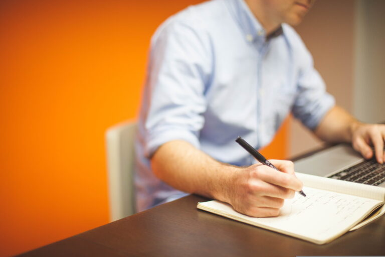 recruitment consultant working at a laptop, making note